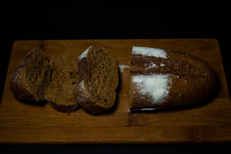 Rye bread sliced on a black background close-up on a cutting board.