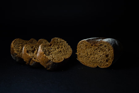 Rye bread sliced on a black background close-up.