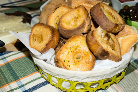 basket filled with bread and slices of toasted bread seasoned with oil and pepper