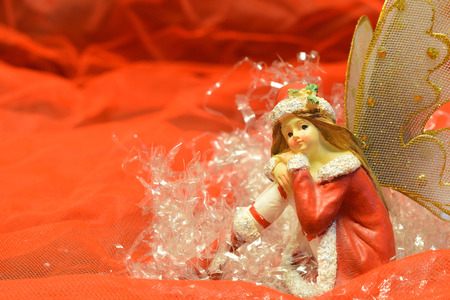 close up of a christmas fairy with various decorations on red background