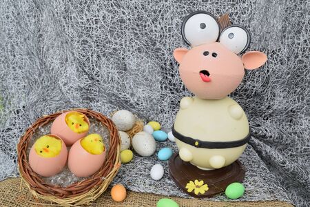 chocolate egg in the shape of a lamb with various decorationsの写真素材