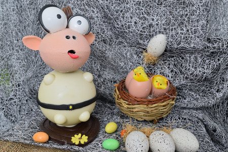 chocolate egg in the shape of a lamb with various decorationsの写真素材