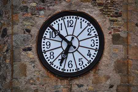 Background, round clock with a light dial on a stone wall