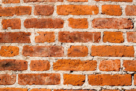 Background, texture. Fragment of old red brick masonry with joining on white cement mortar.