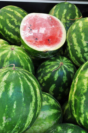 Ripe watermelons. Close-up. Half of the watermelon is wrapped in cellophane. Summer fruits.の写真素材