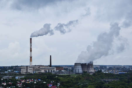 City panorama. View of the pipes of the thermal power plant. Thunderclouds over the city, before the...