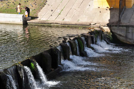 Small waterfall on the river. Family with a child on the river bank. September 03, 2021, Orel, Russia.のeditorial素材