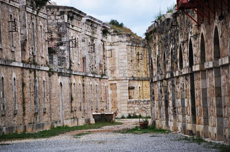 View of the old walls of abandoned houses. A street lined with small stones.