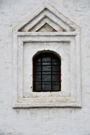 Window in an old building. White wall with a window and carved stone architraves.の写真素材