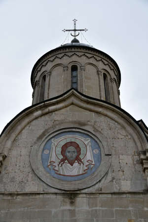 Close-up of the top of the church. Fresco depicting Christ on the facade of the church. old church.