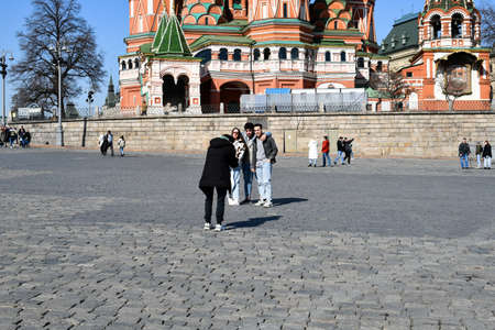 Young people are photographed against the backdrop of St. Basil's Cathedral in Moscow. street photography. March 24, 2022 Moscow, Russia.のeditorial素材