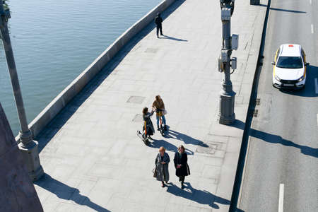 View of the Kremlin embankment. Girls ride electric scooters and take pictures.のeditorial素材