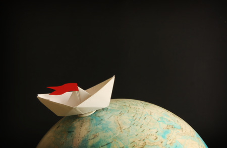 Travel concept with globe and paper boatの写真素材