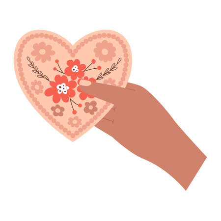 Human hand holds out a valentine card in the shape of a heart, with a floral pattern. A symbol of love, romance, gratitude. Boho Valentine's day. Color vector illustration isolated on a white background.のイラスト素材