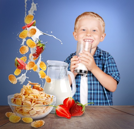 Image of smiling little boy with glass of milk and healthy meal on the wood tableの写真素材
