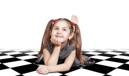 Dreaming  little girl with long hair lying on checkered surfaceの写真素材