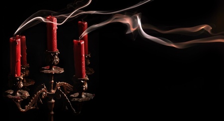 Horizontal image blown candle with line of smoke in massive bronze candlestickの写真素材