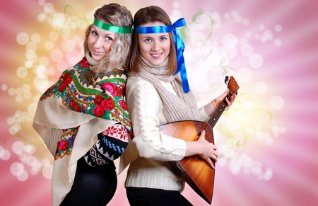Two russian beauties with folk attributes on the pink backgroundの写真素材