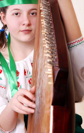 Closeup portrait pretty tennage girl playing by falk ukrainian instrument - banduraの写真素材