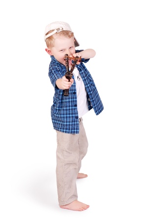 Expressive little boy bully shooting with slingshot over white backgroundの写真素材