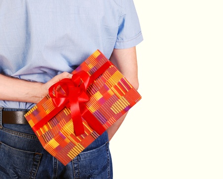 Gift box in man hand behind his backの写真素材