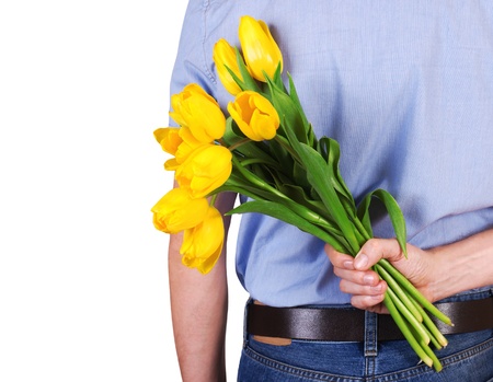 Closeup image of man back with bouquet of yellow tulips in handの写真素材