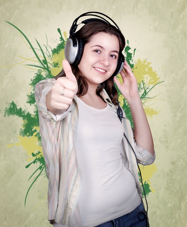Teenage girl in headphones on green abstract backgroundの写真素材