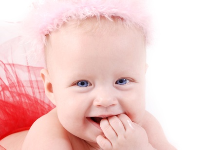 Funny baby girl with fingers into her mouthの写真素材