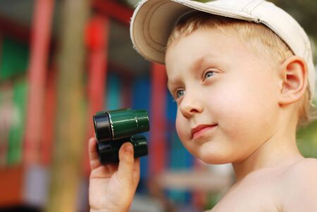 Portrait little boy with binoculars in outdoorの写真素材