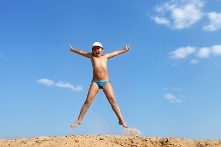 Happy jumping girl in blue skyの写真素材