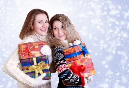 Happy smiling girlfriends with christmas presentsの写真素材