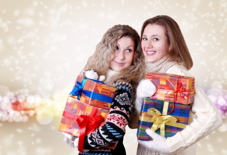 Happy smiling girlfriends with christmas presentsの写真素材