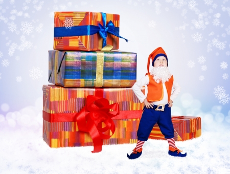 Little funny gnome stand near christmas gift boxesの写真素材