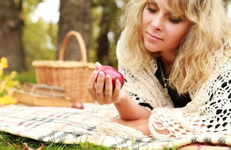Beautiful young woman enjoy  with ripe apple on autumn picnicの写真素材
