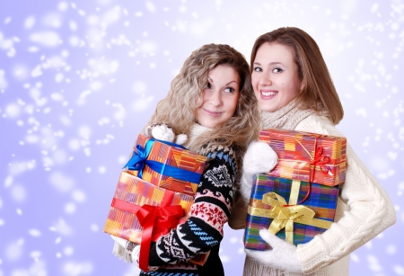 Happy smiling girlfriends with christmas presentsの写真素材