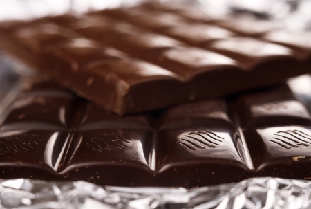 Closeup image milk and black chocolate bars over foil wrapperの写真素材