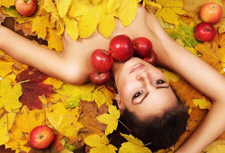 Beautiful Lady Autumn lying on the yellow leaves carpetの写真素材