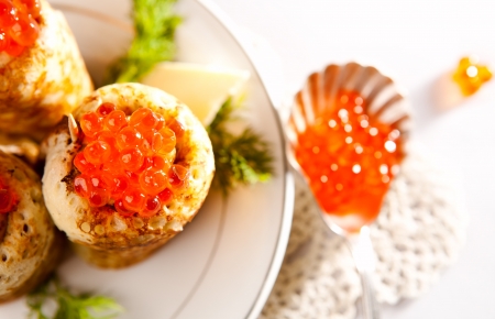 Rolled snack with salmon caviar and russian pancakesの写真素材