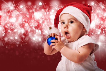 Dfde girl in santa's hat portrait over red shining backgroundの写真素材