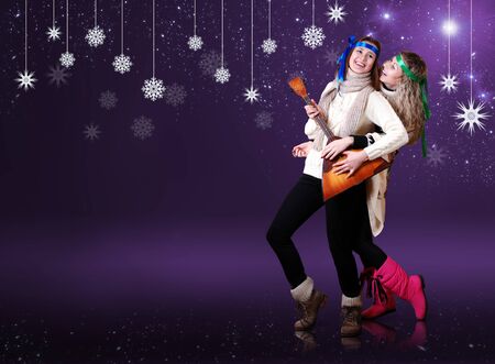Beauty girls with balalika dancing over purple background with snow flakesの写真素材