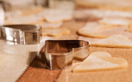 Closeup image of raw christmas cookies and dough cutter on the tableの写真素材