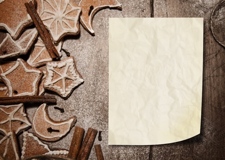 Wooden bacckground with christmas cookies and paper blankの写真素材