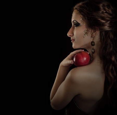 Portrait seductive posing girl with red apple over dark backgroundの写真素材