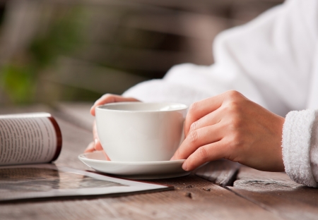 Refreshing morning tea. Woman hands with cup and magazineの写真素材