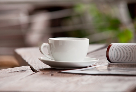 White cup with morning beverage and magazine on the wood tableの写真素材