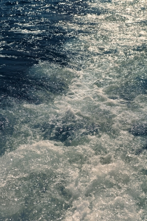 Bubbling boat track on the waterの写真素材
