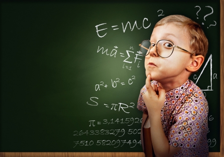 Funny portrait clever pupil boy on school board backgroundの写真素材
