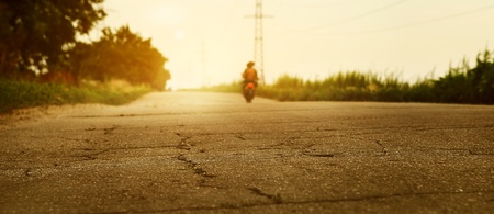 Sunset desserted highway with biker silhouette