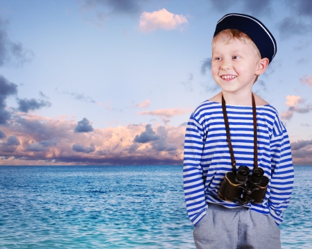 Little boy in sailor's uniform with binocular at the sea view backgroundの写真素材