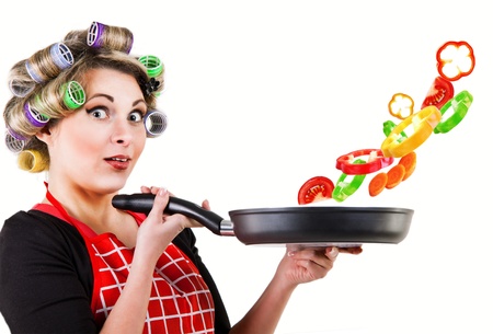 Portrait pretty housewife with pan for frying and fresh vegetablesの写真素材